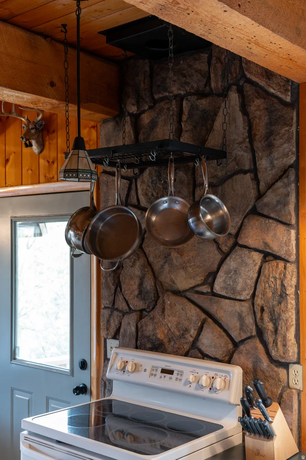 Stone-clad wall with a ceiling-mounted pot rack