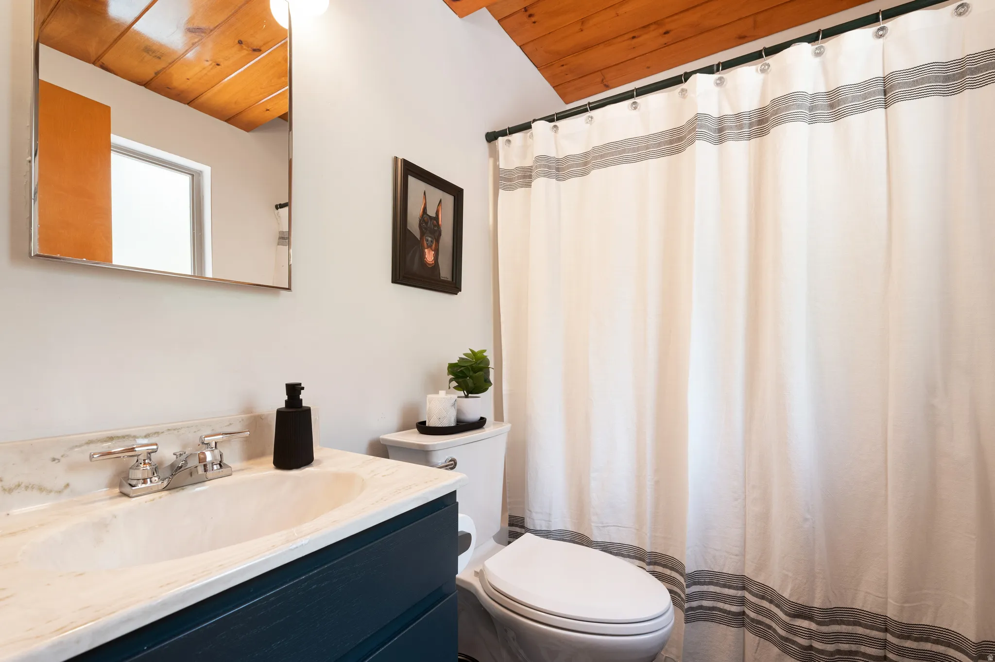Wood-clad ceiling with an attached vanity featuring a single basin sink