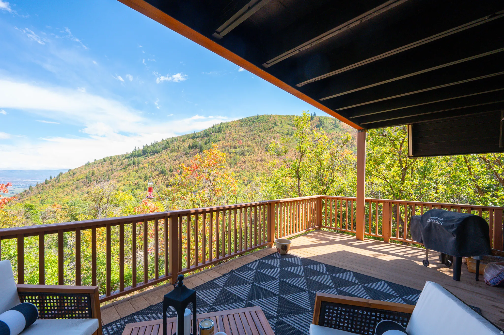 Expansive outdoor deck with wood railing, composite decking, and a covered ceiling