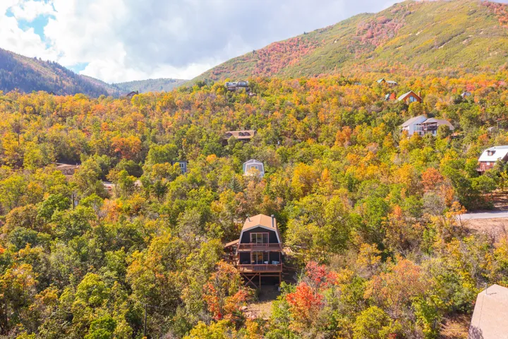 Two-story residence with a peaked roof, exterior balcony, and a multi-level deck