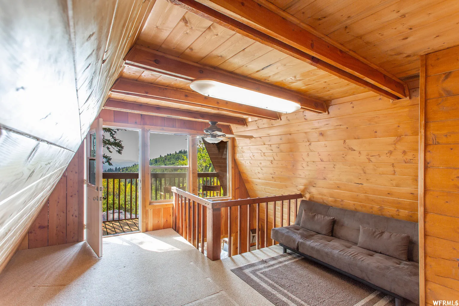 Wood-paneled walls and ceiling, exposed wood beams, and a ceiling fan with integrated lighting