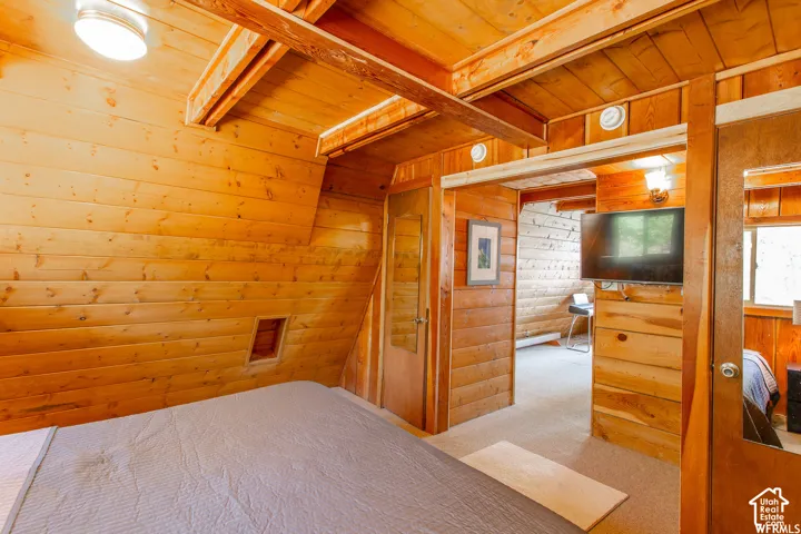 Wood plank walls, wood beam ceiling, and wood flooring visible through the doorway