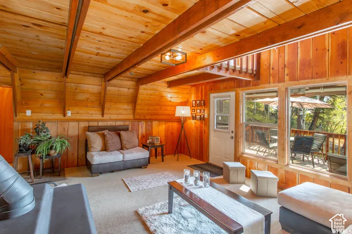 Vaulted wood-paneled ceiling, exposed wood beams, wood-paneled walls, built-in hearth, and expansive windows