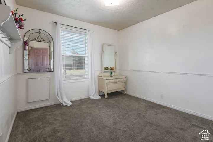 Wall-mounted heating unit, window with blinds, and neutral carpeting