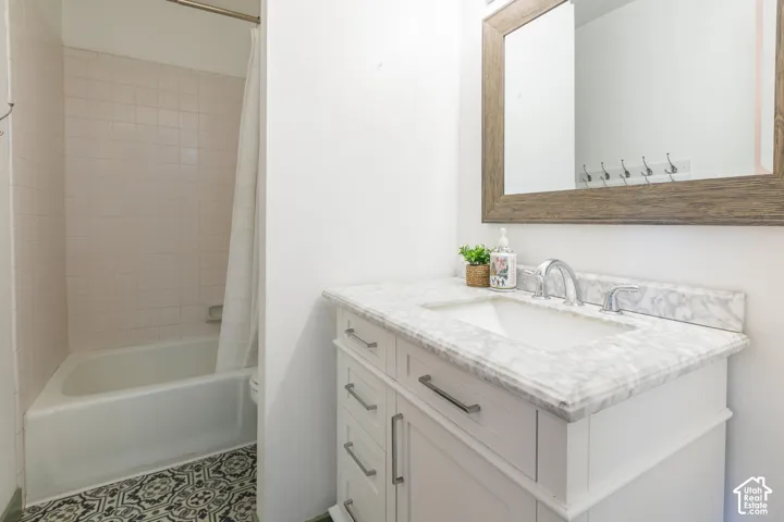 White vanity with a marble-patterned countertop and undermount sink