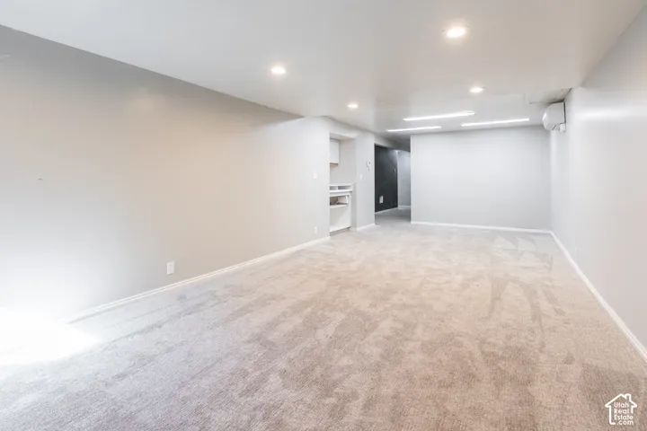 Expansive room with neutral carpeting and light gray walls