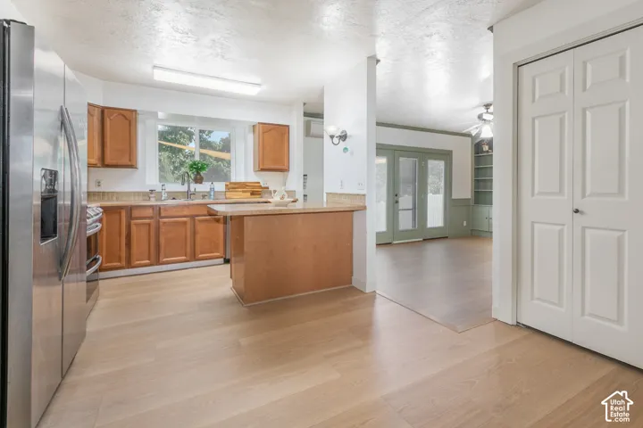 Kitchen with wood-finish flooring, built-in cabinetry, an integrated sink, and stainless steel appliances