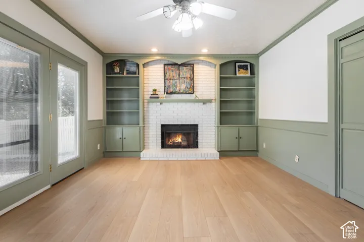 Light wood-finish flooring with a white brick fireplace