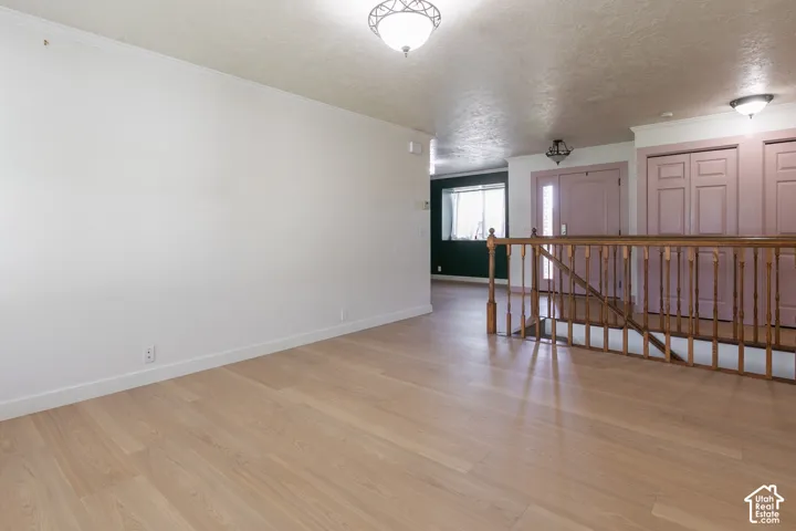 Light wood-finish flooring with white baseboards and neutral wall tones