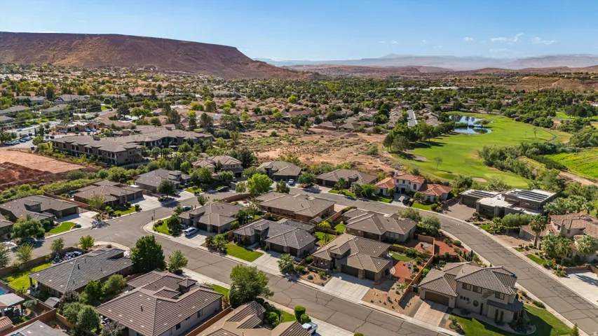 Residential neighborhood with diverse architectural styles, featuring a golf course and natural landscape