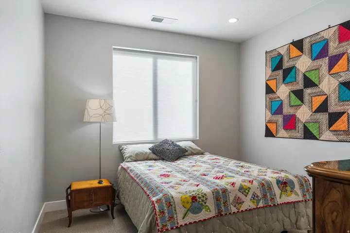 Recessed ceiling lighting, a window with cellular shades, and neutral wall tones