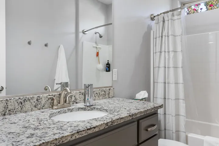 Vanity with speckled countertop, undermount sink, and brushed nickel fixtures