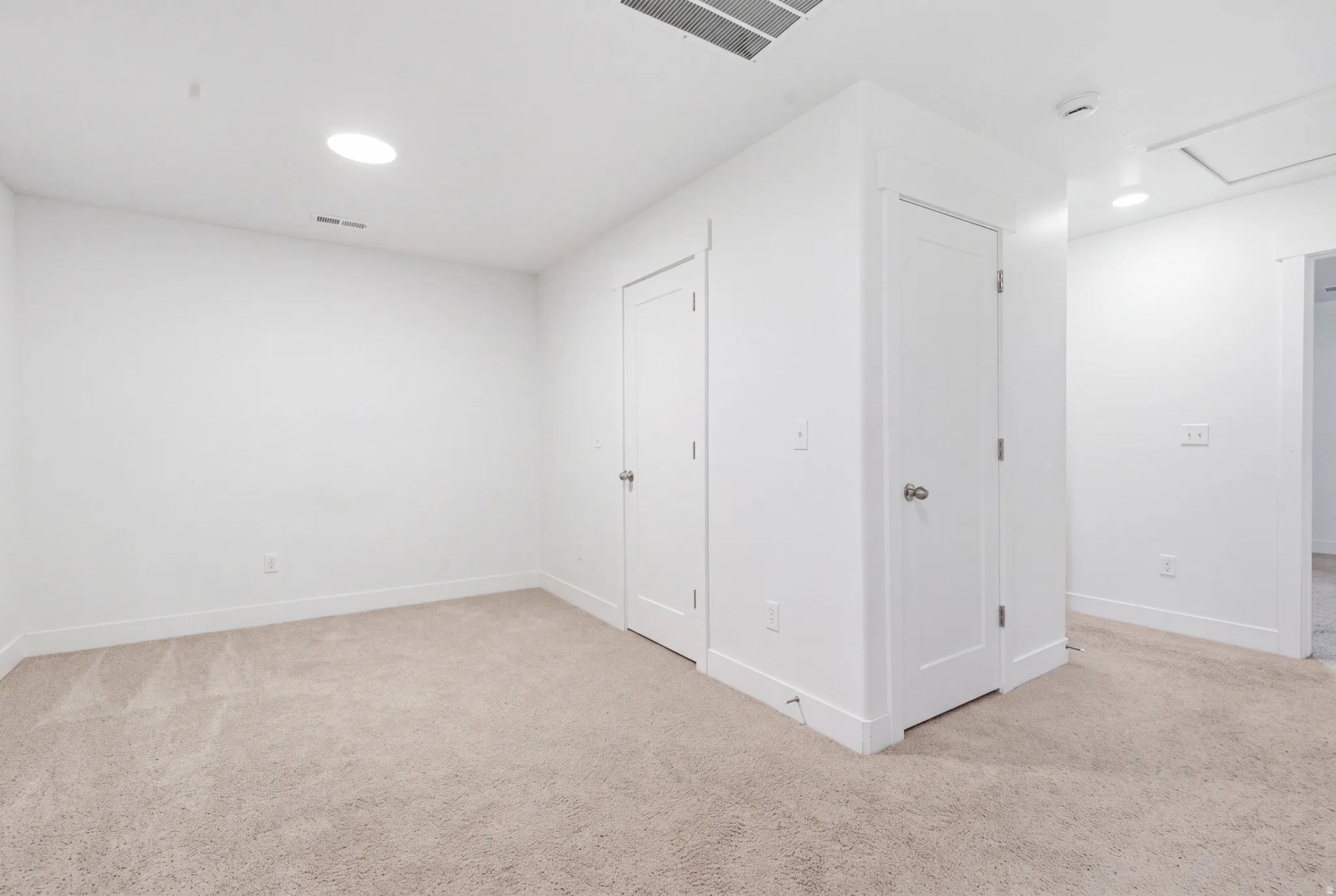 Neutral tone wall paint, recessed lighting, and carpet flooring