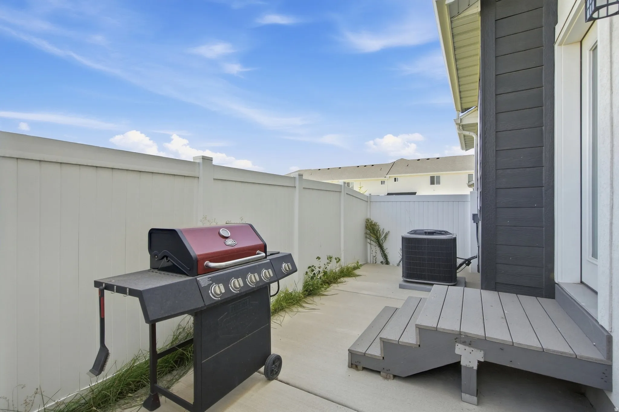 Private fenced patio area featuring a concrete slab and composite decking