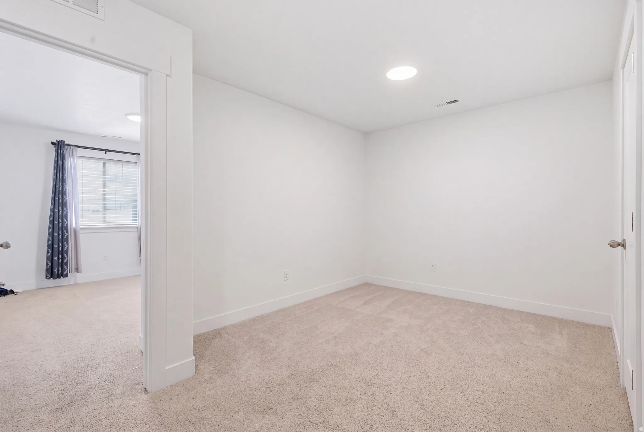 Recessed lighting, neutral wall paint, and carpeting