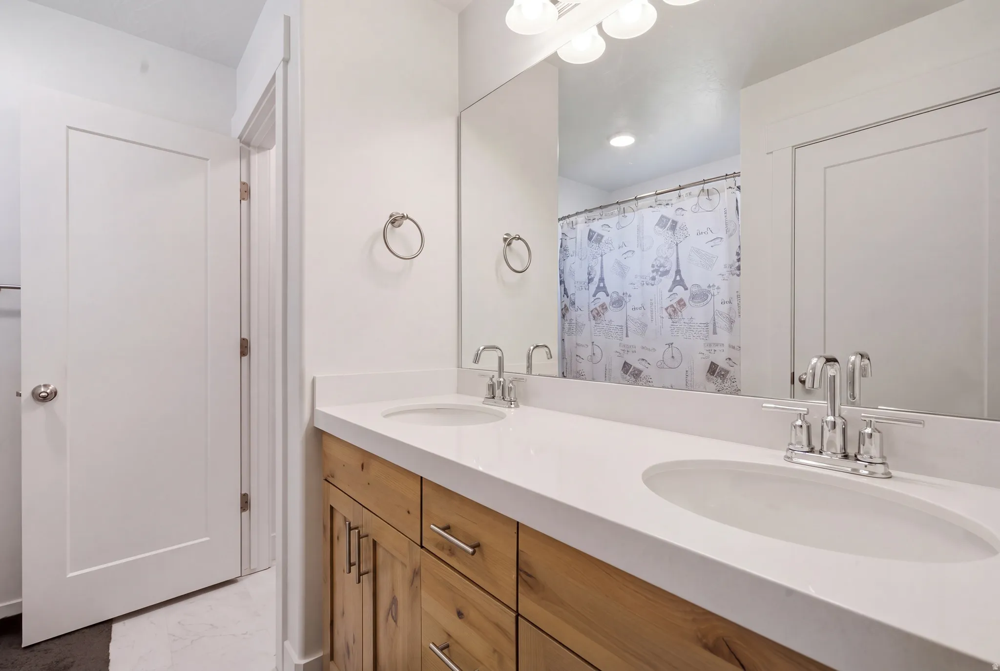 Dual vanity with white undermount sinks, chrome fixtures, and a light-toned countertop