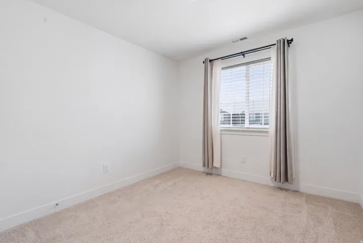 Neutral wall paint, ceiling fan, carpet flooring, and window with blinds