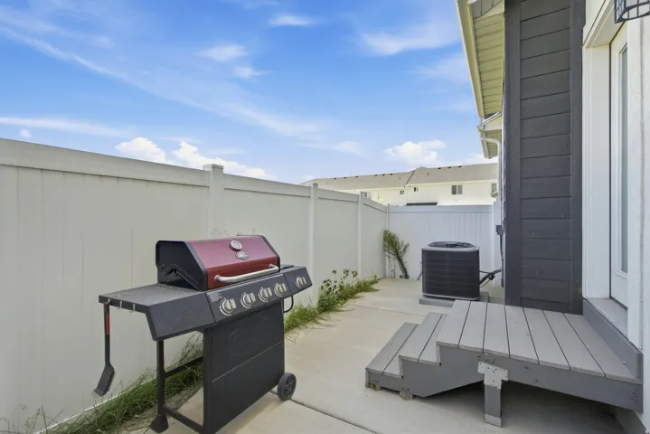 Private fenced patio area featuring a concrete slab and composite decking