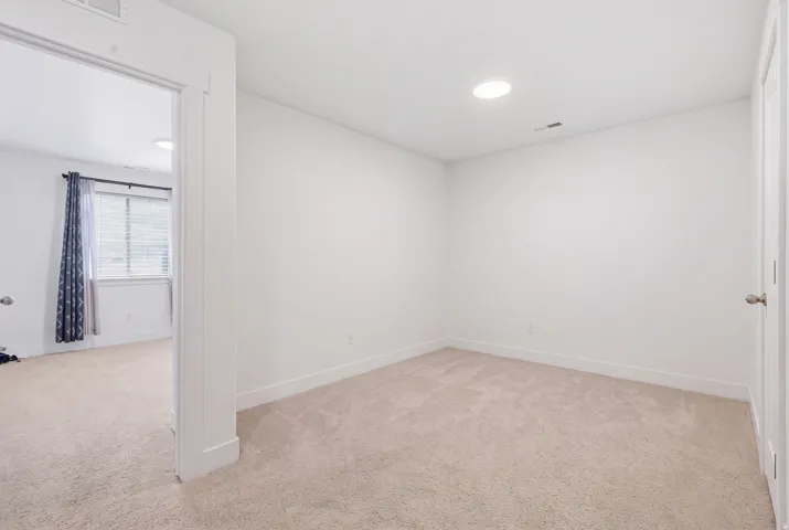 Recessed lighting, neutral wall paint, and carpeting