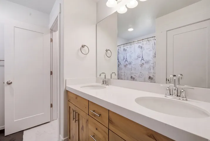 Dual vanity with white undermount sinks, chrome fixtures, and a light-toned countertop