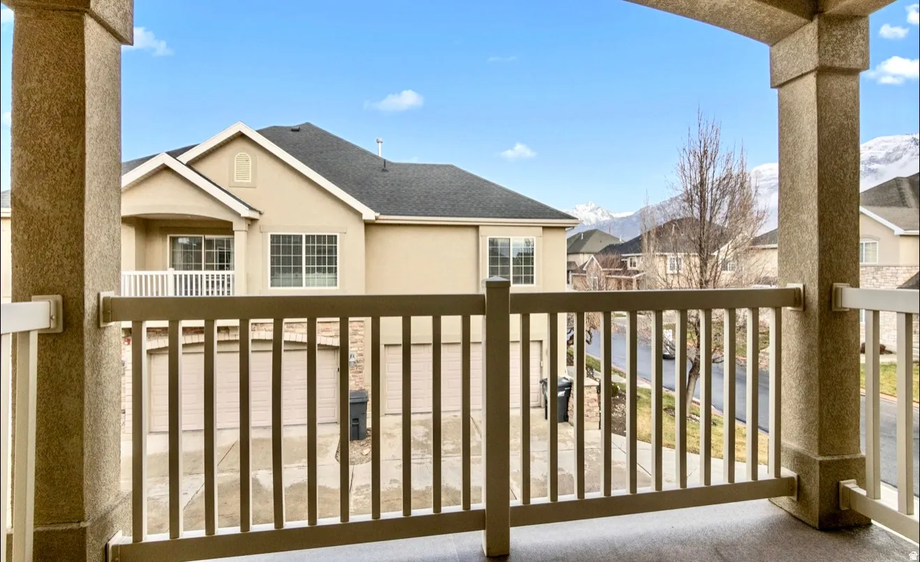Balcony with textured columns, a painted railing, and distant mountain scenery