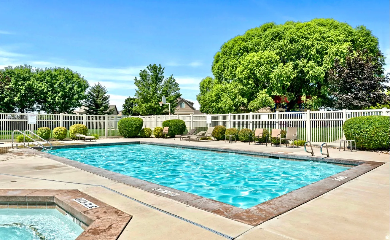 Rectangular swimming pool with a surrounding concrete deck and integrated hot tub