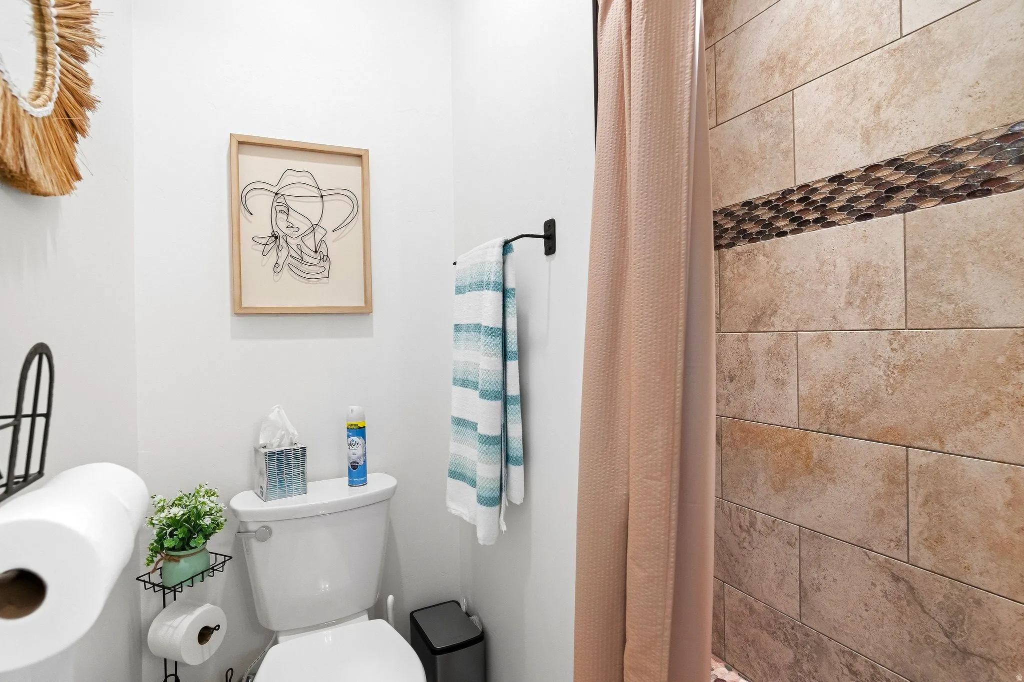 Shower with natural stone tile and decorative mosaic accent