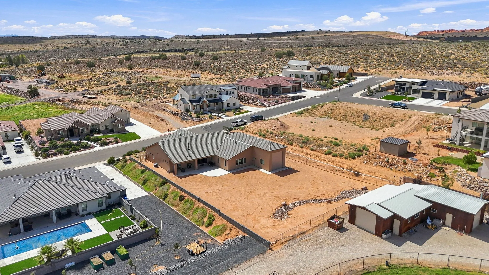 Expansive property featuring a large undeveloped lot, detached garages/storage buildings, and a residential structure with an extended covered patio
