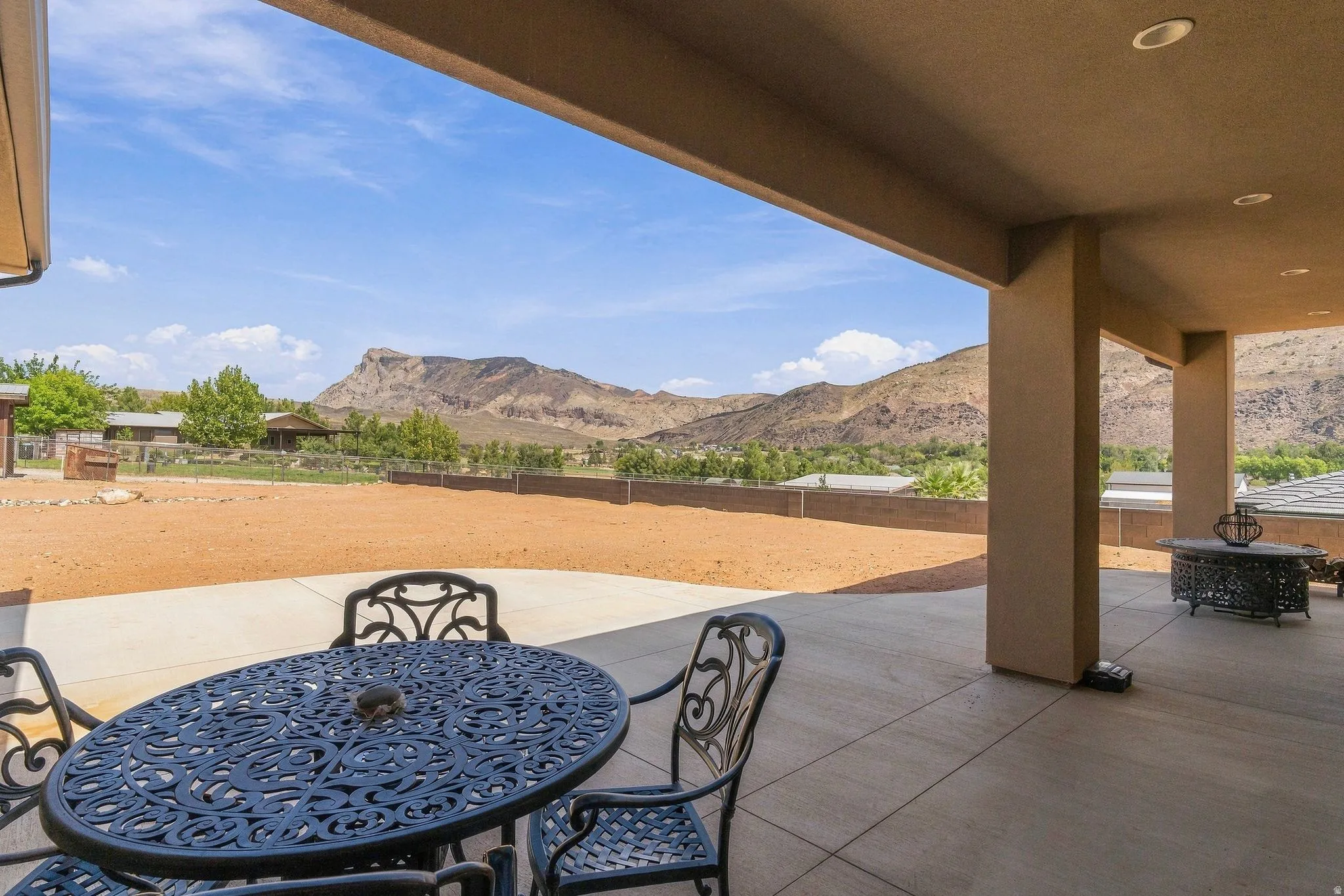 Expansive covered patio with recessed lighting, integrated structural columns, and a concrete surface