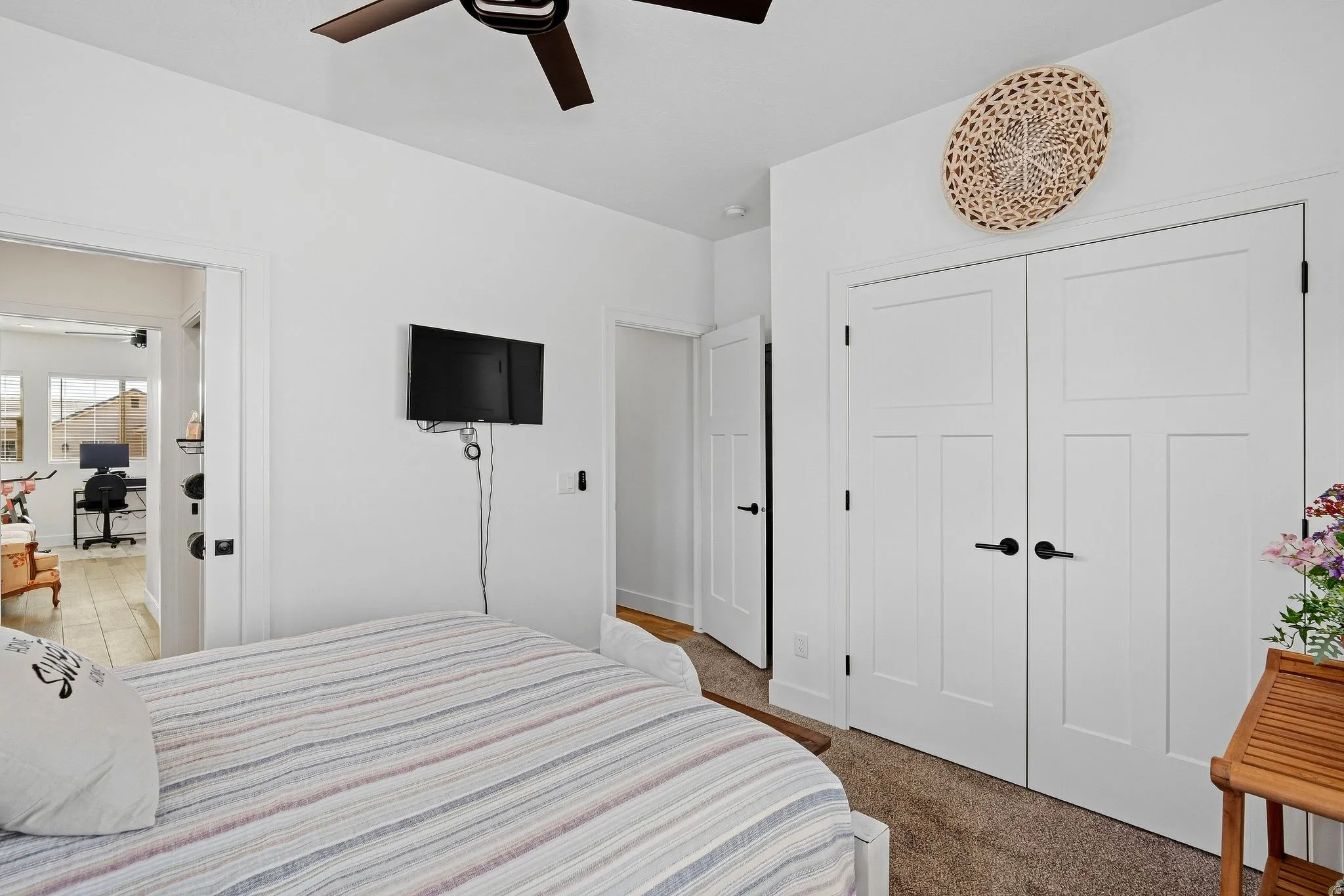 Ceiling fan, white paneled doors, dark hardware, carpet flooring, light wall color