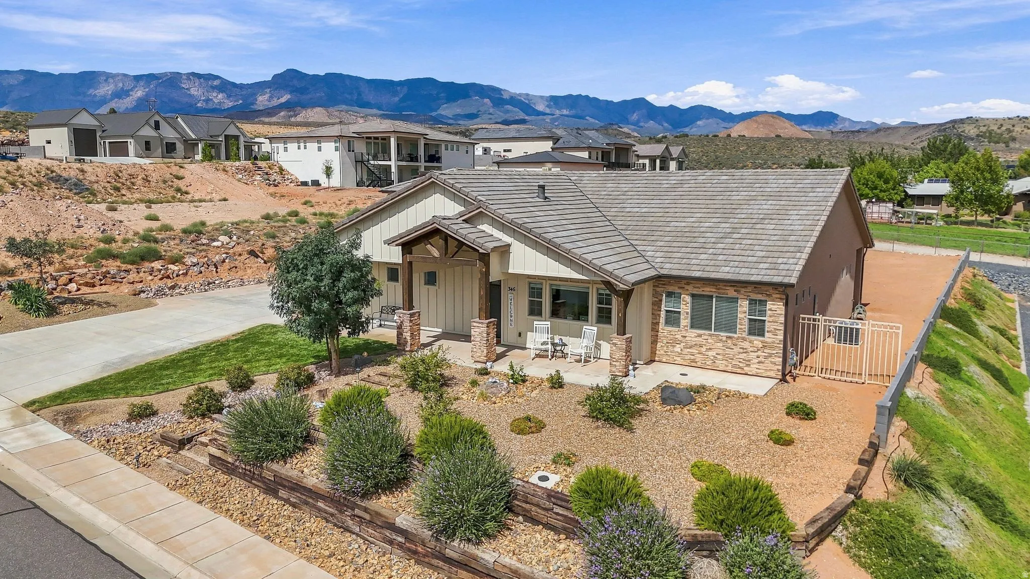 Ranch-style residence featuring a covered entry, stone veneer accents, and a tile roof