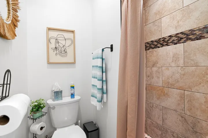 Shower with natural stone tile and decorative mosaic accent