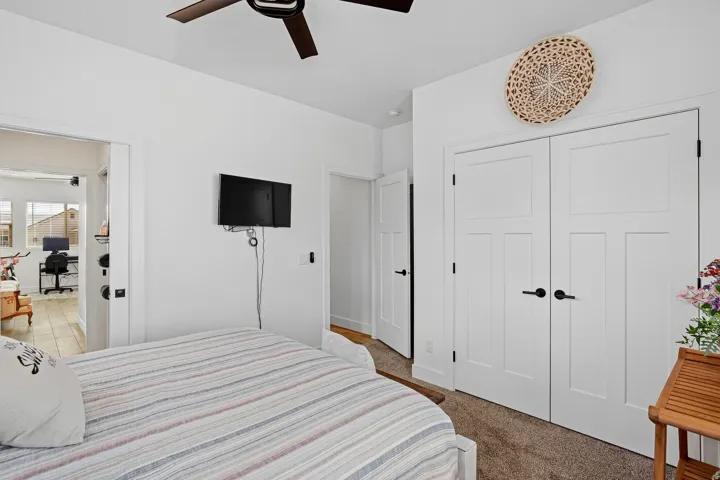 Ceiling fan, white paneled doors, dark hardware, carpet flooring, light wall color