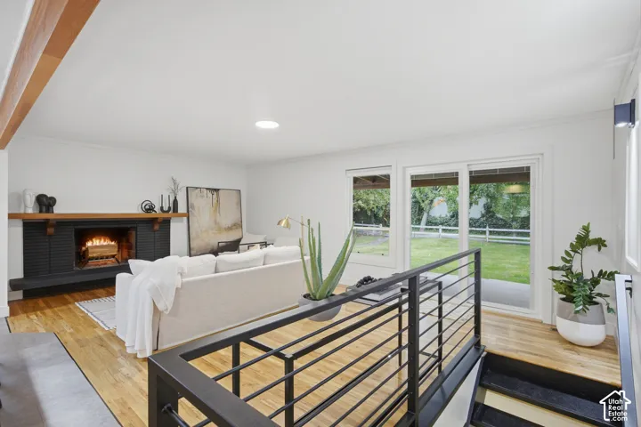 Wood-finish flooring throughout, featuring a fireplace with a wood mantel, black surround, and hearth