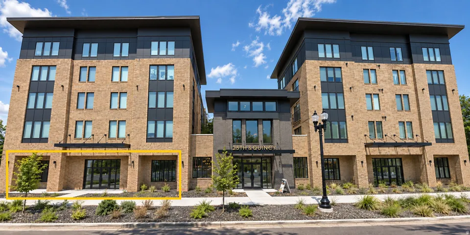 Modern multi-story building featuring a brick and dark panel facade