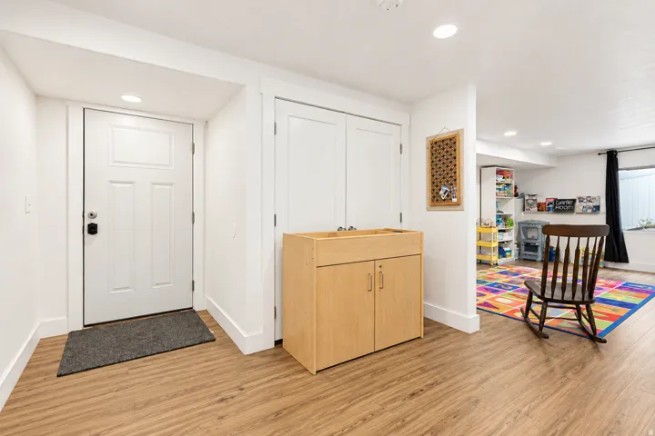 Wood-finish flooring, recessed lighting, and a paneled door