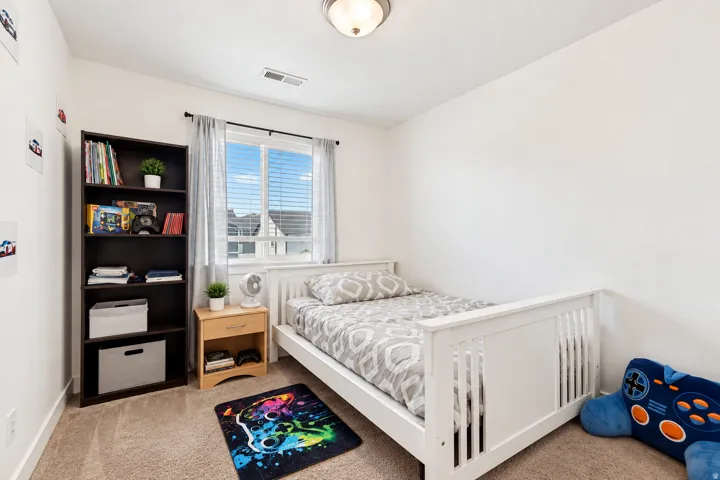 Recessed lighting fixture, light beige carpet, white walls, and a window with blinds and drapes