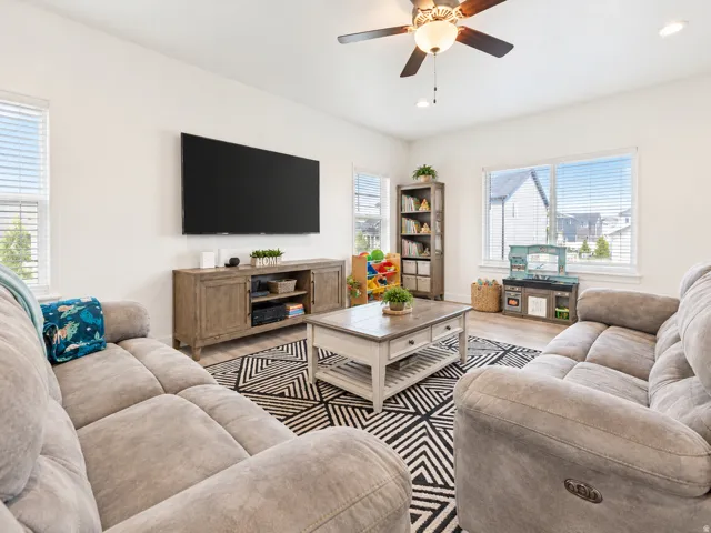 Recessed lighting, wood-finish flooring, ceiling fan with light fixture, multiple windows with blinds, and light-toned walls