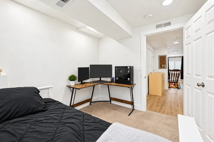 Recessed lighting, wood-finish flooring, white paneled door, and carpeted area