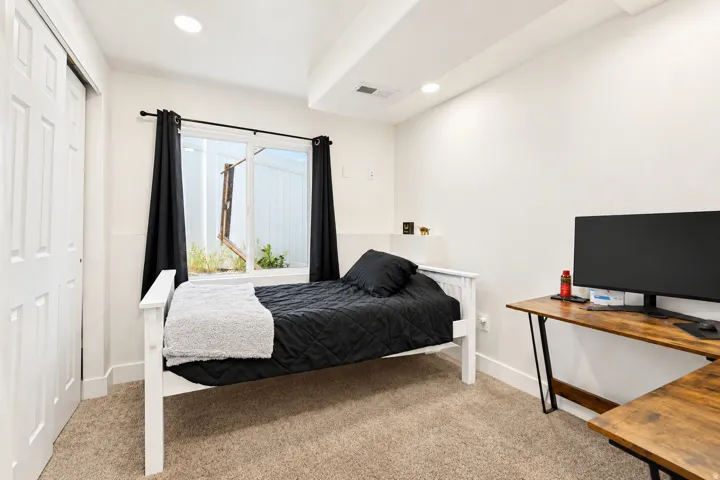 Plush carpet flooring, recessed lighting, and a white paneled bi-fold closet