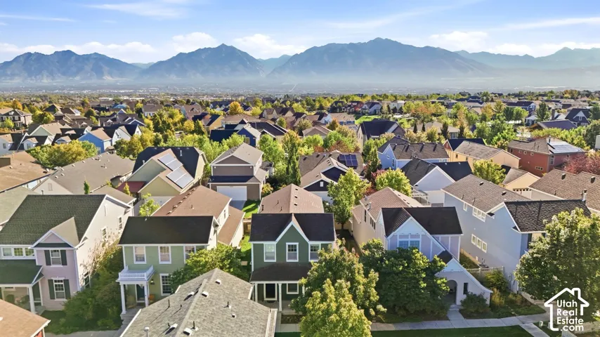 Expansive neighborhood featuring various architectural styles, mature trees, and mountainous scenery