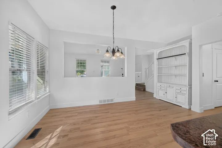 Wood-finish flooring throughout, white painted walls, and a built-in hutch with shelving and cabinetry