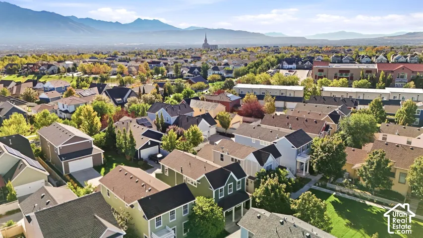 Expansive neighborhood setting with diverse residential architecture and mature landscaping, framed by distant mountains