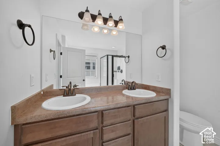Dual vanity with integrated sinks, a wide mirror, and a multi-bulb light fixture