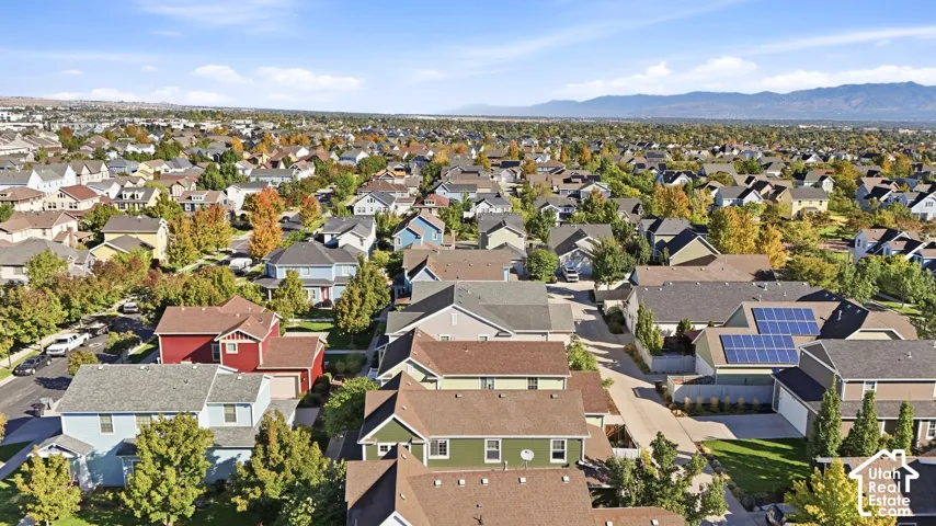 Residential neighborhood featuring varied single-family homes, mature trees, and mountainous scenery