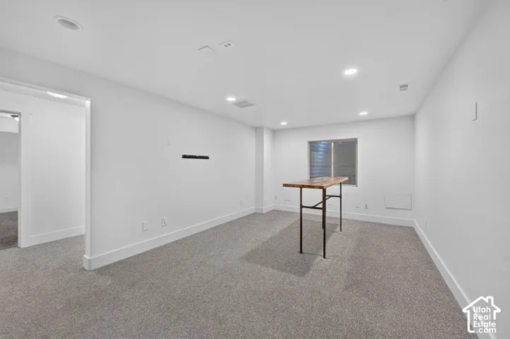 Recessed lighting, wall-to-wall carpeting, and a window with blinds