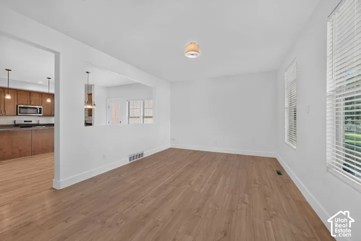 White walls with wood-finish flooring, recessed half-wall opening, and dual windows