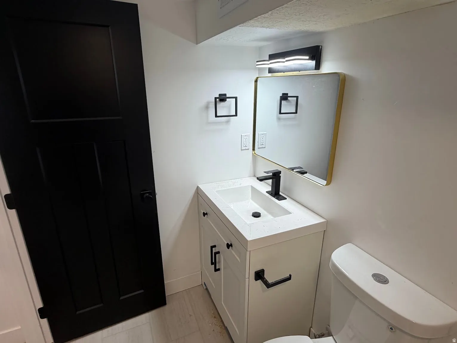 Vanity with integrated sink, matte black faucet, and cabinet storage