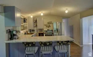Kitchen featuring a breakfast bar,  cabinetry, stainless steel appliances.