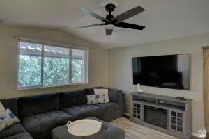 Angled ceiling with a dark-bladed ceiling fan, wall-mounted television.